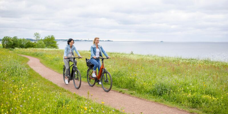 Zwei Frauen fahren Rad an der Ostsee
