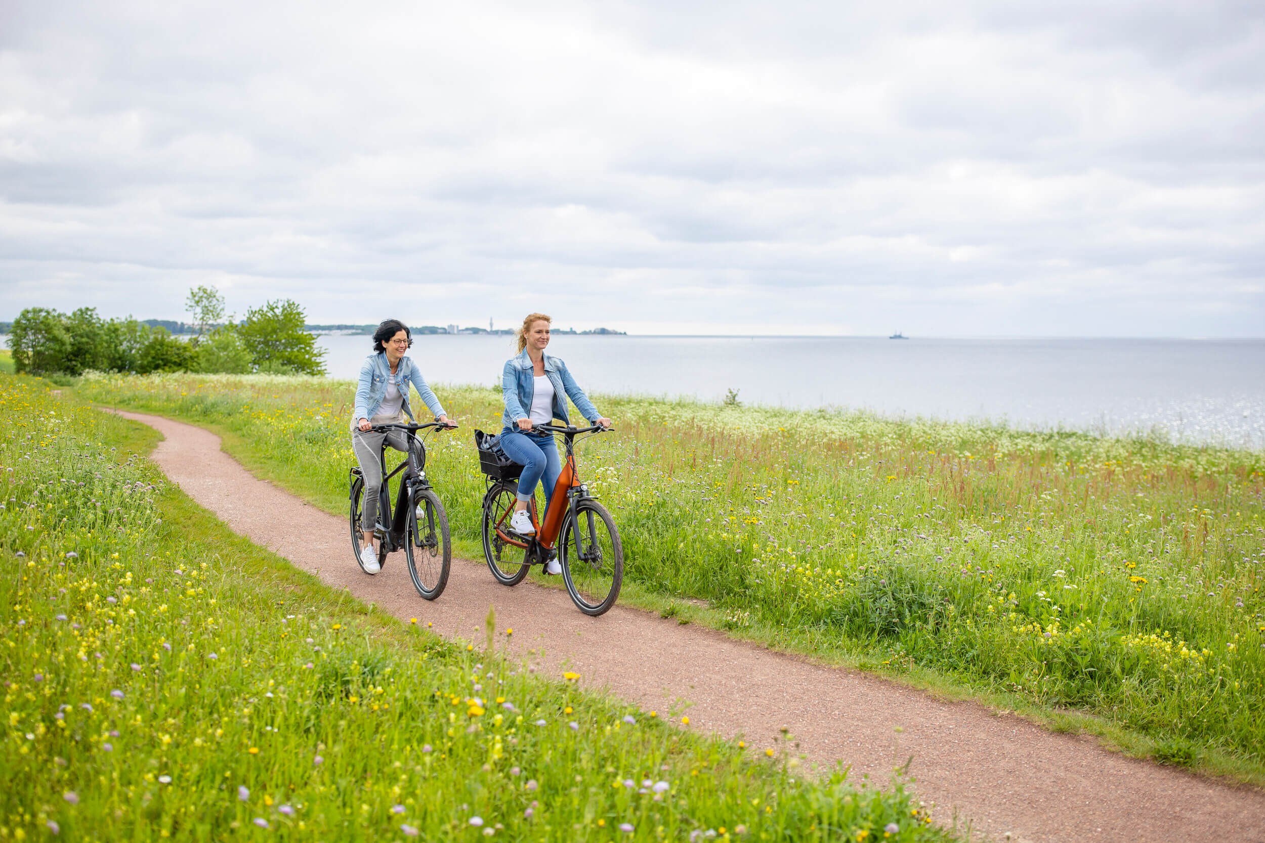 Zwei Frauen fahren Rad an der Ostsee